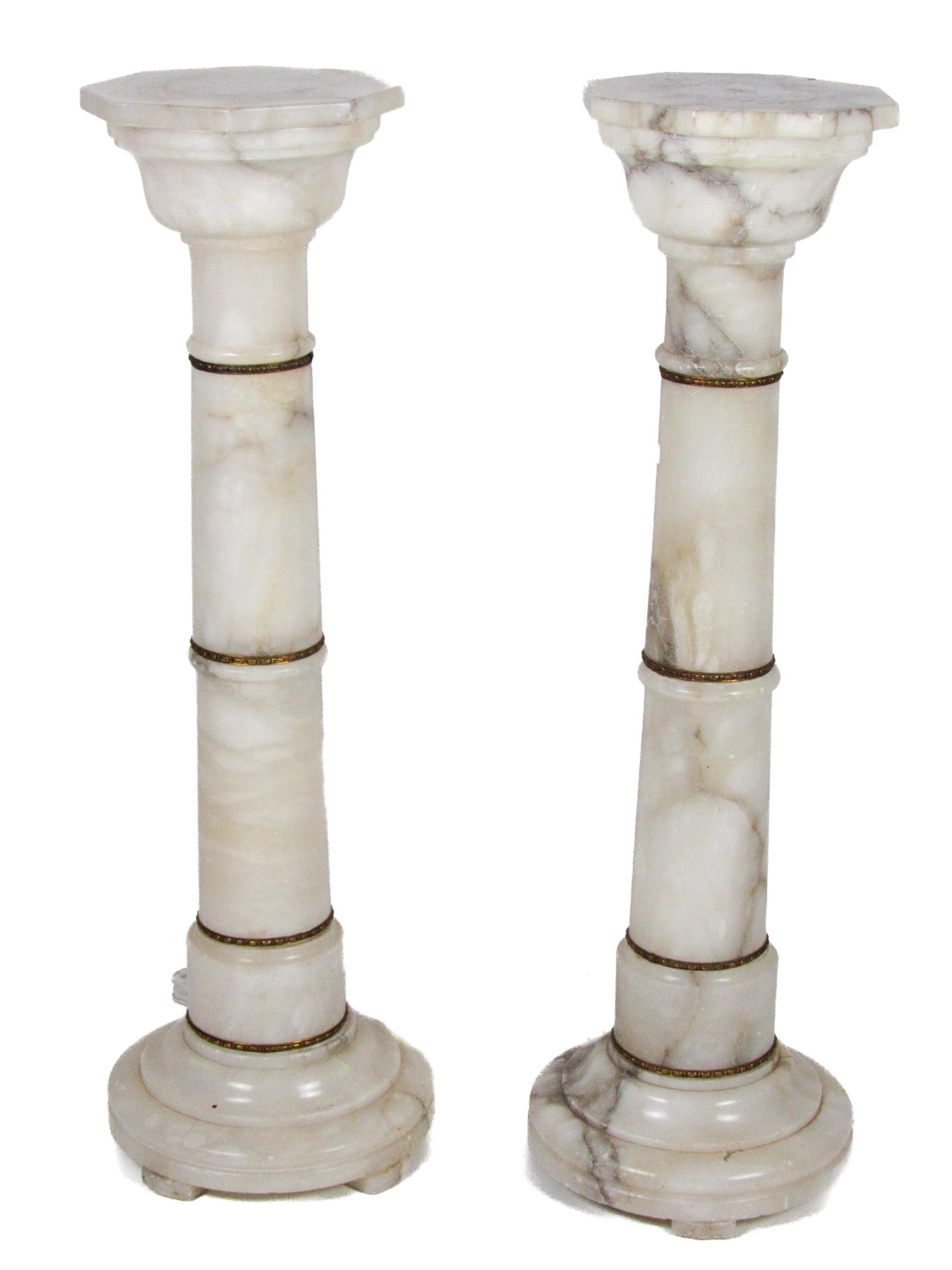 A pair of alabaster Plinths, with octagonal tops on circular bases, each approx. 91cms high (