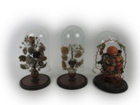 A pair of Victorian shellwork Floral Displays, a similar Display of Fruit, each in matching glass