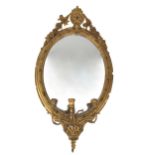 A Victorian giltwood Girandole, the oval frame with ornate cartouche and decorative border, with