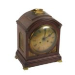 A late 19th Century mahogany Bracket or Mantle Clock, the arched top with brass carrying handle,