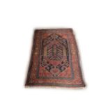 An attractive antique woolen oblong Carpet, the central navy ground with floral medallion, the