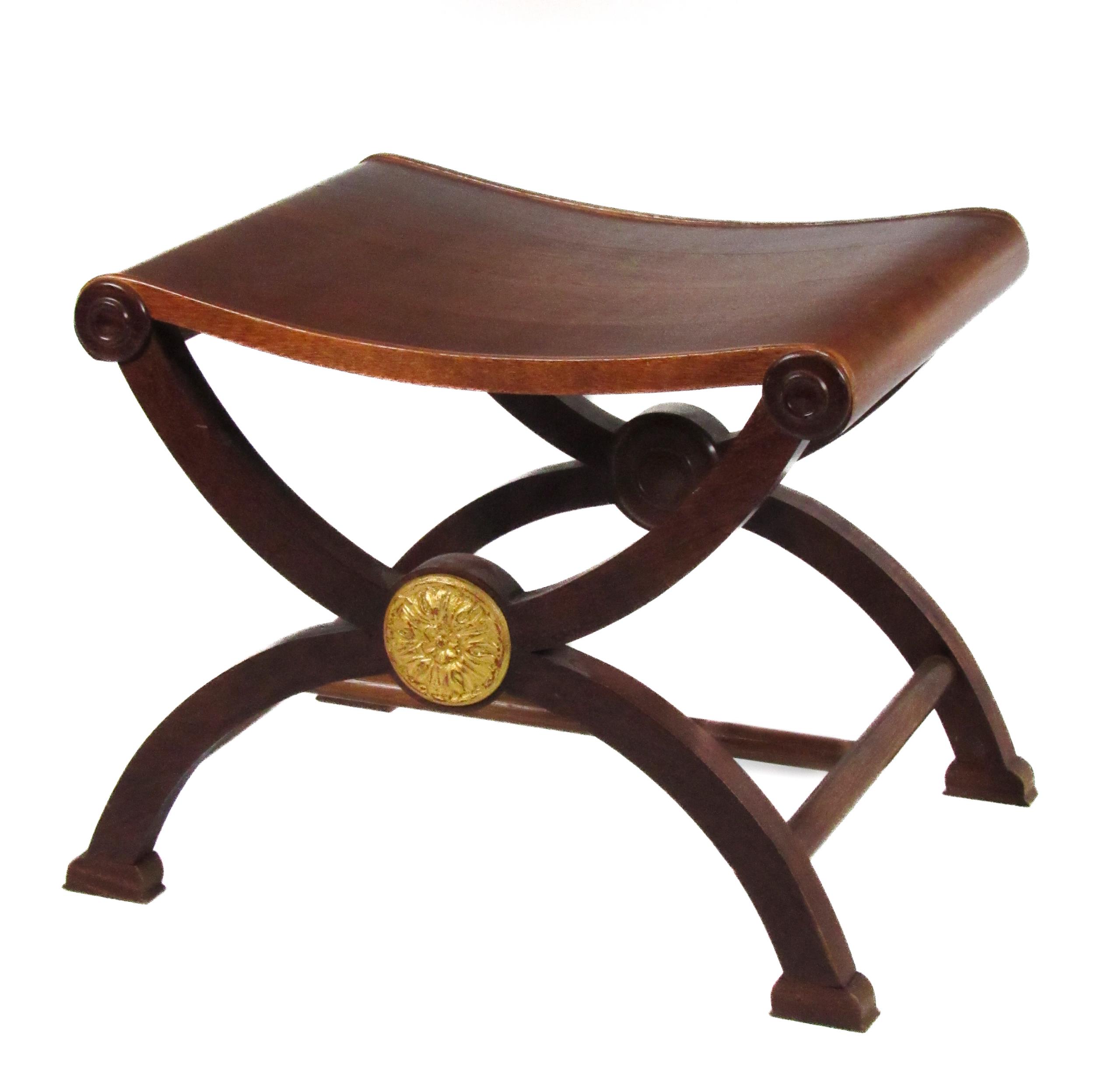 A Regency style mahogany X framed Window Stool, with shaped seat and circular gilded motifs. (1)