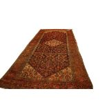 A large semi-antique woollen Carpet, the central navy ground panel with floral design, and cream
