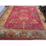 An attractive Irish woolen Carpet, probably Donegal, the centre claret ground panel with floral