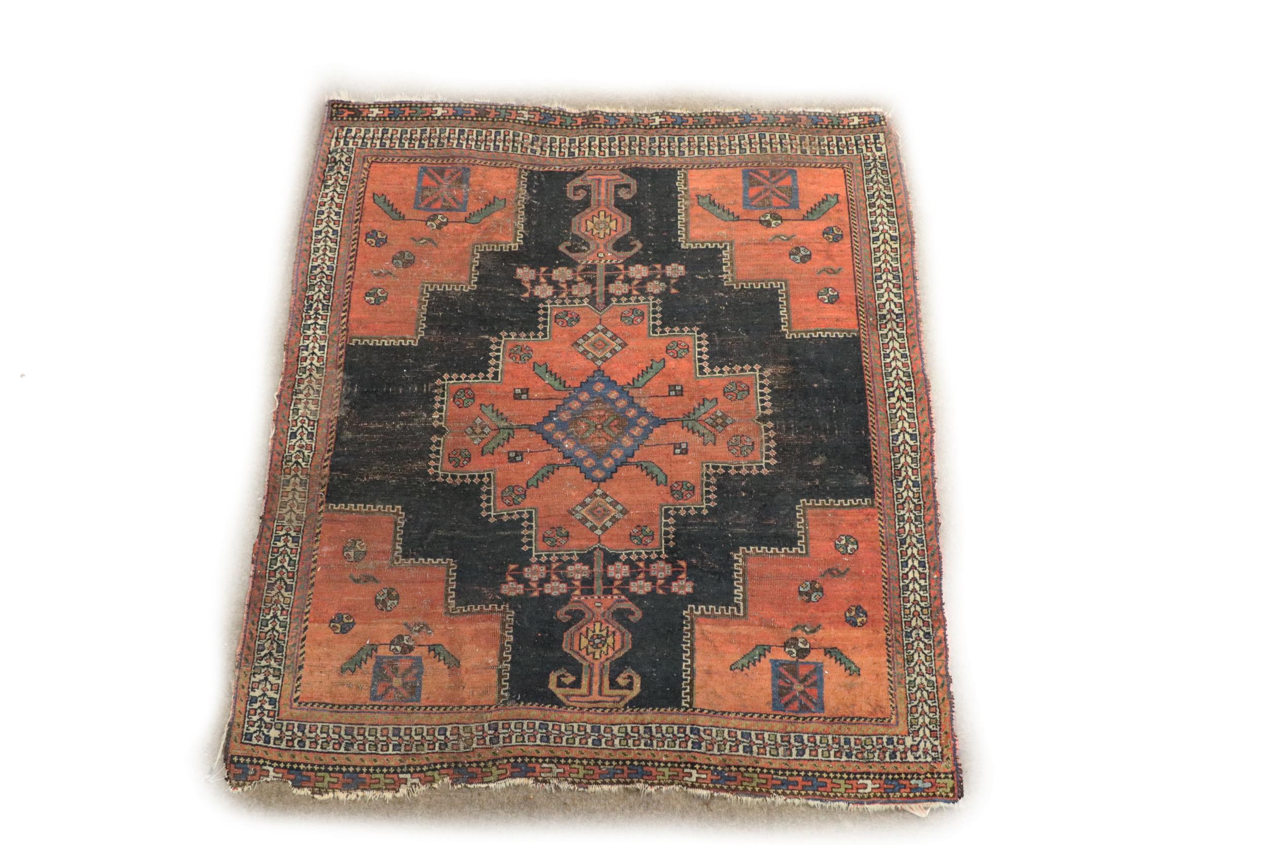 A small antique Middle Eastern Rug, the central navy ground panel with large floral geometric