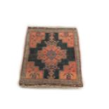 A small antique Middle Eastern Rug, the central navy ground panel with large floral geometric