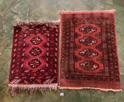 2 small red patterned rugs