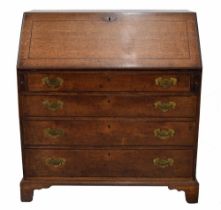 George III oak bureau, the hinged fall front enclosing a divided interior with drawers, over three