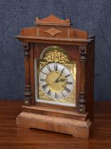 Walnut electric mantel clock, the brass arched dial with silvered chapter ring with Roman numerals