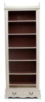 Decorative painted pine open bookcase, the shelved upper on a shallow plinth with two short drawers,