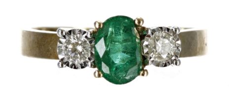 Emerald and diamond three stone 9ct yellow gold ring, the oval emerald 0.50ct approx, flanked by two