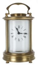 Carriage clock timepiece, within a circular bevelled glazed brass case, 6.75" high