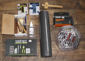 Selection of guitar related tools to include a guitar mat, cork neck rest, quantity of Ernie Ball