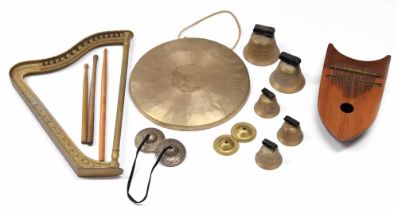 Wooden percussion shield shaped thumb piano, small metal harp frame, five hand bells and a gong
