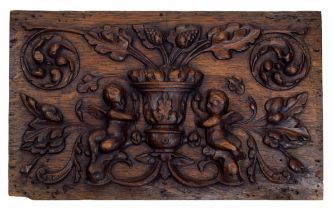 Interesting 17th century carved oak panel, depicting an urn with oak leaves flanked by two putti