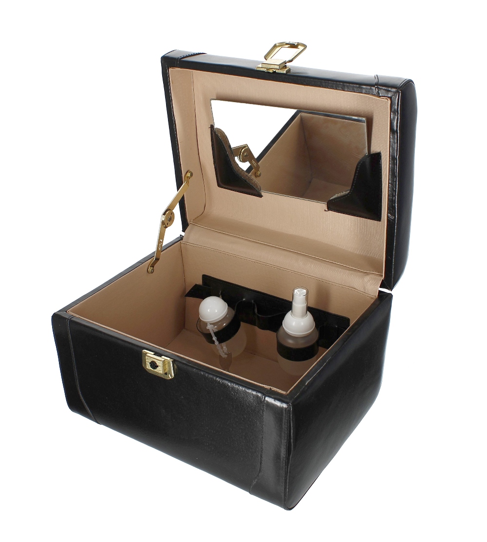 Franzen leather vanity case, the hinged cover with carry-handle, enclosing a plastic bottle and