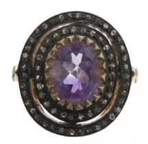 Stylish vintage style dress ring set with a central oval-cut amethyst and a double halo of rose-