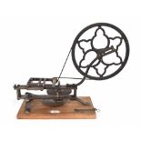 Good antique steel and cast iron wheel cutting engine, mounted upon a rectangular canted pine