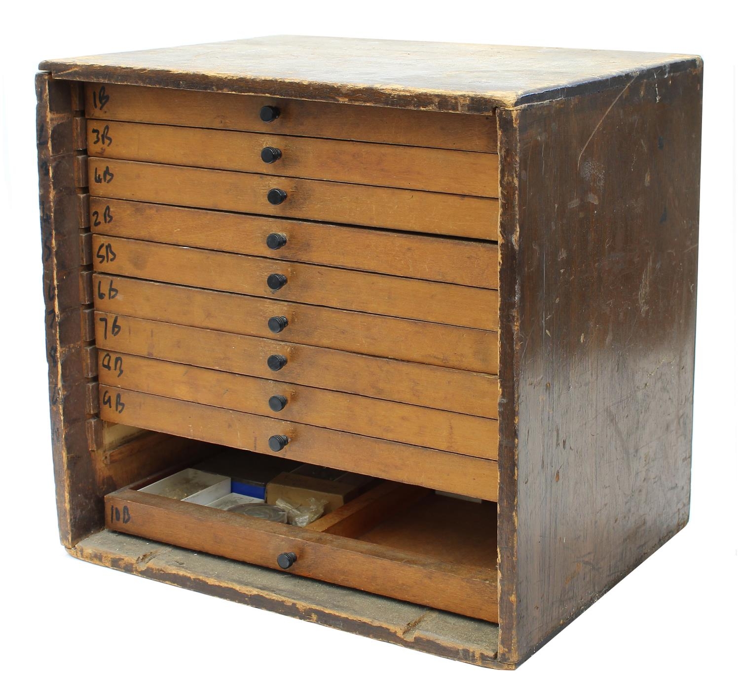 Twelve drawer wooden chest containing a quantity of watch parts including balances, stems, wheels,