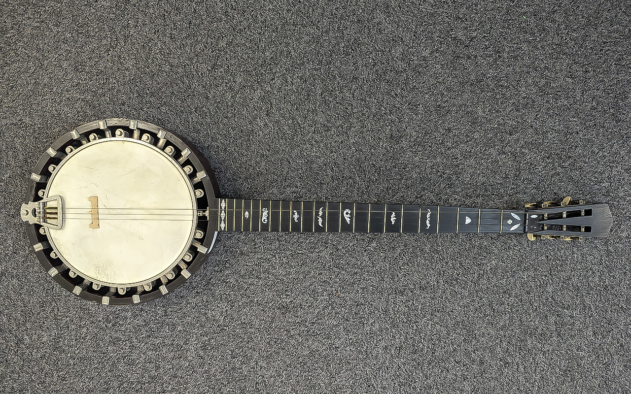 CLIFFORD ESSEX CO; a cased six string banjo with mother of pearl inlaid detail to the rosewood neck,