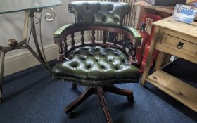 Captain's Chair in Dark Green Leather, raised on splayed legs with castors, measures height 84'',