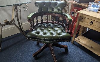 Captain's Chair in Dark Green Leather, raised on splayed legs with castors, measures height 84'',