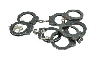 Four Sets of Hiatts Handcuffs with gun metal finish. Marked ''Hiatts, Made in England''. Complete
