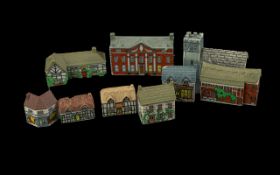 Box of Miniature Wade Cottages comprising a church, pub, manor house, and assorted cottages.
