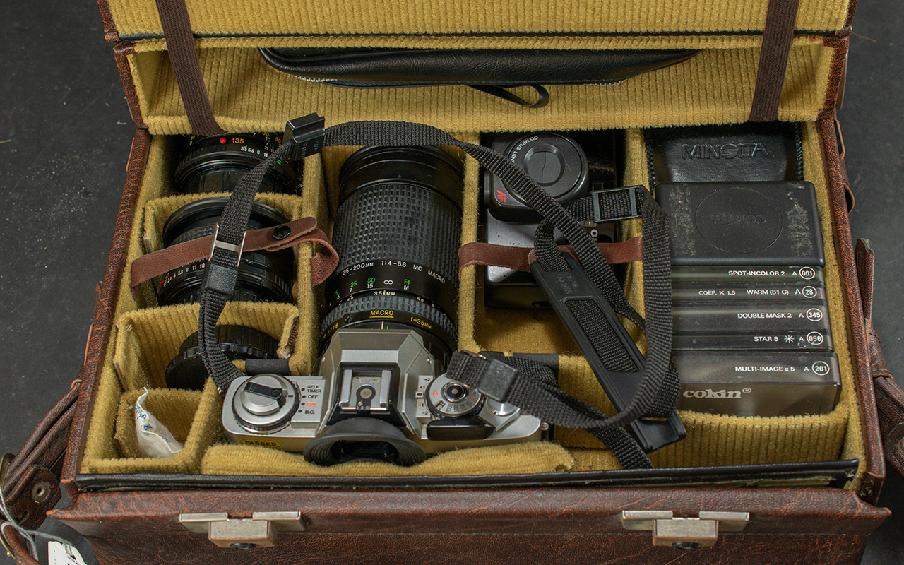 Minolta Camera, in fitted brown leather case, complete with lenses and accessories.