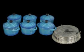 Six Blue Stonewear Soup Bowls with Lids, together with a set of silver tone place mats with stand.
