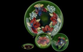 Four Pieces of Moorcroft, including a pin tray, two small dishes and a plate 10'' diameter. Dark