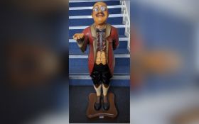 Wooden Butler Statue, holding out his hand for a tip, wearing a tailcoat and glasses. Measures