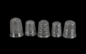 Five Thimbles, comprising four hallmarked silver thimbles and one other white metal.