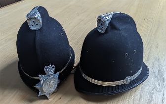 Two Police Helmets, one complete with badge.