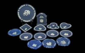 Box of Dark Blue Wedgwood comprising a small mantle clock, ten pin dishes, and wall plates. 13 items