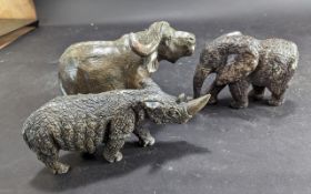 Three Cast Animal Figures, comprising a buffalo, a rhinoceros, and an elephant. Tallest measures 6''