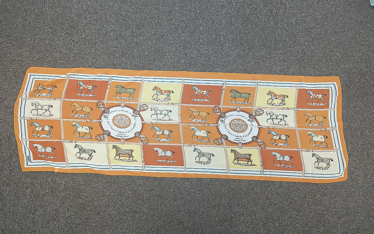 Hermes Vintage Scarf, decorated with horses with orange and cream background. Measures 60'' x 20''.
