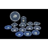 Box of Dark Blue Wedgwood comprising a small mantle clock, ten pin dishes, and wall plates. 13 items