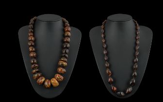 Two Amber Coloured Bead Necklaces, one 22'' length with larger beads, one 24'' smaller beads.