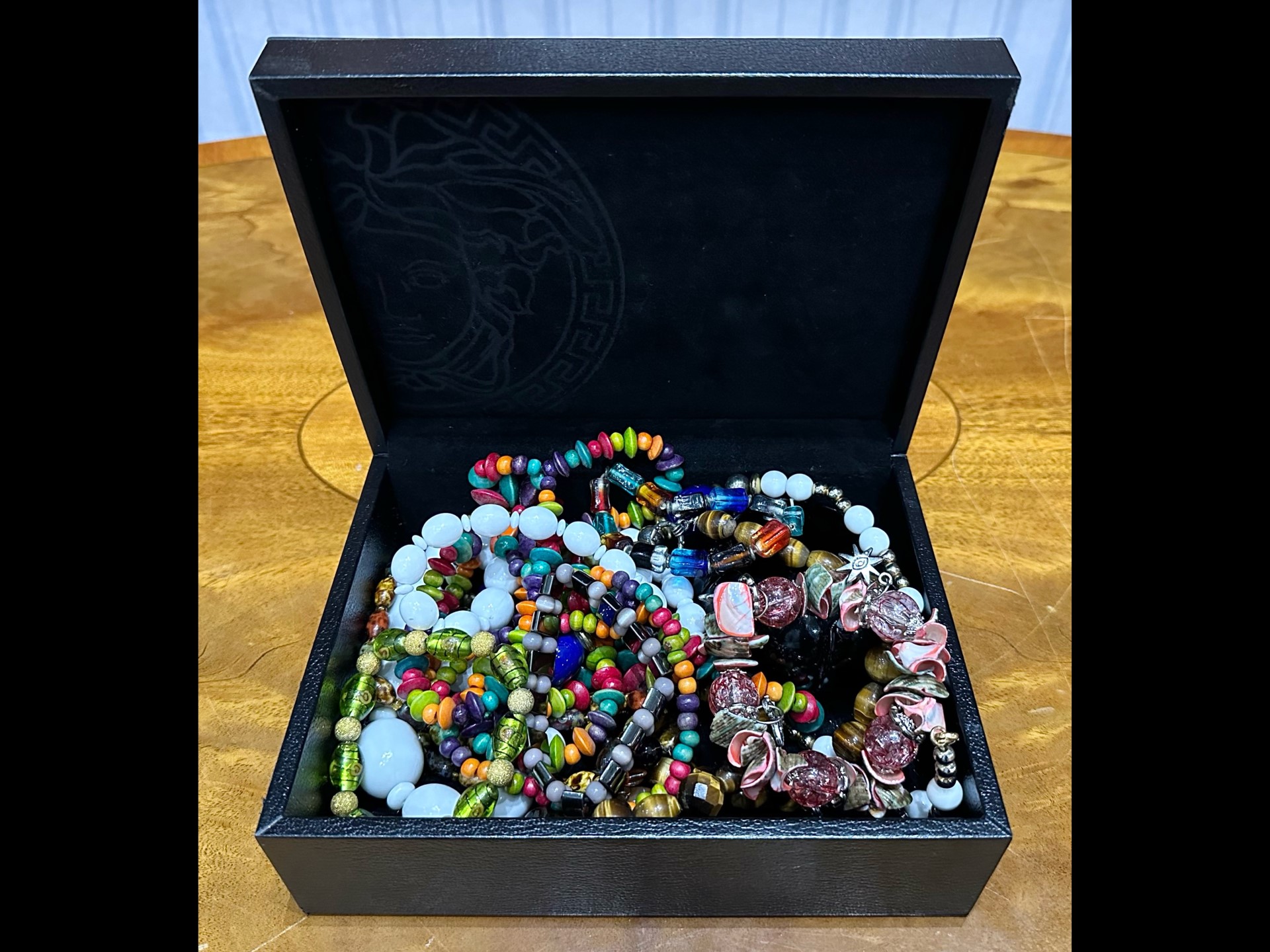 Box of Costume Jewellery, comprising assorted coloured beads, bracelets, etc., housed in a black