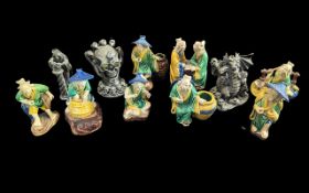 Collection of Eight Small Japanese Figurines, depicting figures playing checkers, carrying water