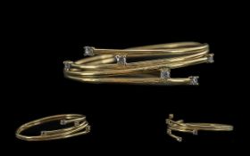 Ladies - contemporary designed 9ct gold bangle, set with small faceted diamonds, marked 9ct. the