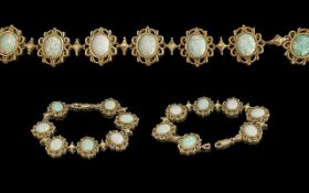 Ladies - attractive 9ct gold 7 stone opal set bracelet, all opals set in ornate open-worked setting.