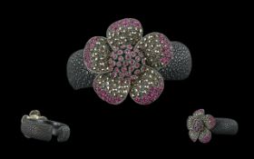 Black Embossed Bangle, set with a large flower decorated with pink Swarovski crystals.