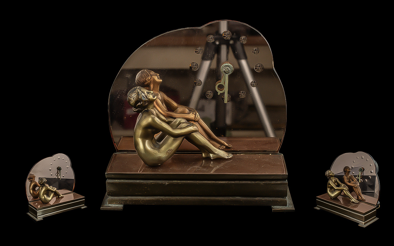 Art Deco Style Electric Clock, featuring a seated nude figure, with a bronze mirrored backdrop