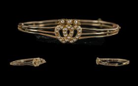 Victorian period 1837 - 1901 ladies 15ct gold bangle, set with intertwined heart to centre, set with