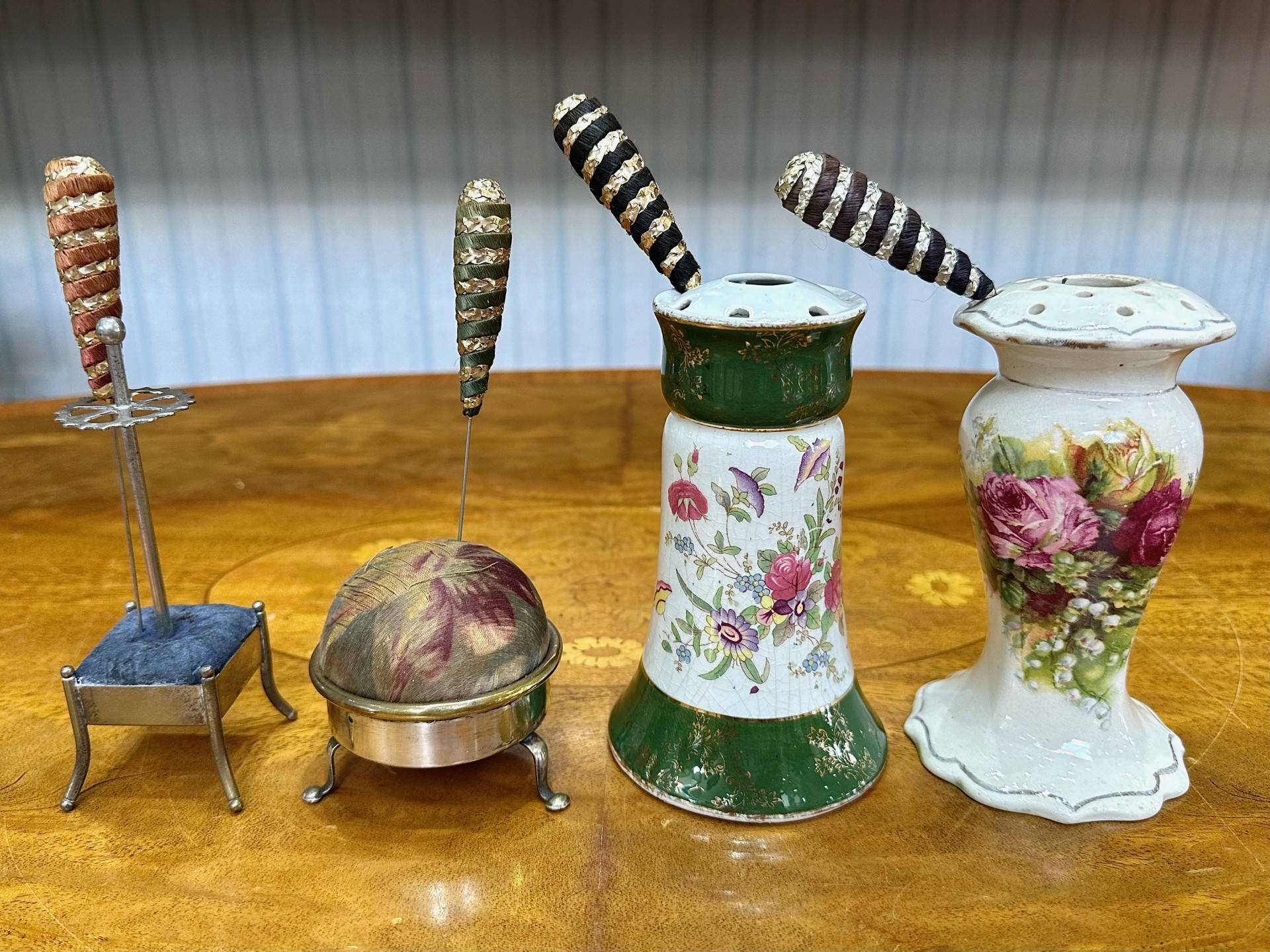 Four Vintage Hat Pin Holders, comprising two china floral decorated holders, an EPNS stand with