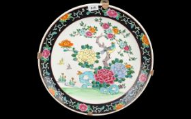Oriental Charger, decorated with prunus and tropical bird, black border, brass strap work mount.