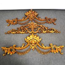 Pair of gilt composition door pelmet decorations, and one similar,
