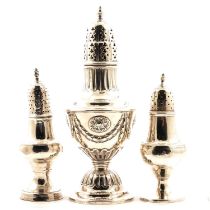A silver sugar caster and two silver pepperettes